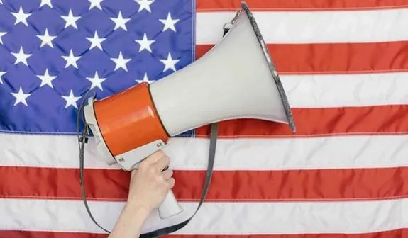 Megaphone being held in front of American flag