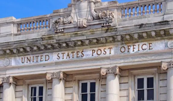 The front of a post office building with the words, "United States Post Office"