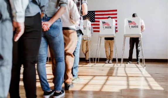 Voters complete their ballots and wait in line at a polling center