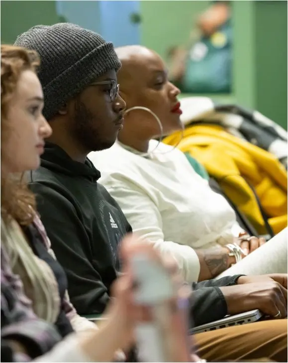 A row of students listen in a lecture hall