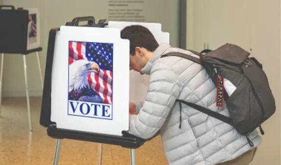 A person completing their ballot in a voting booth